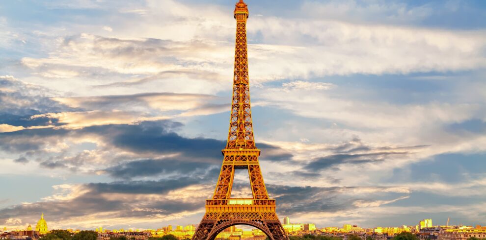 Eiffel Tower in Paris, France illuminated at sunset with city skyline view
