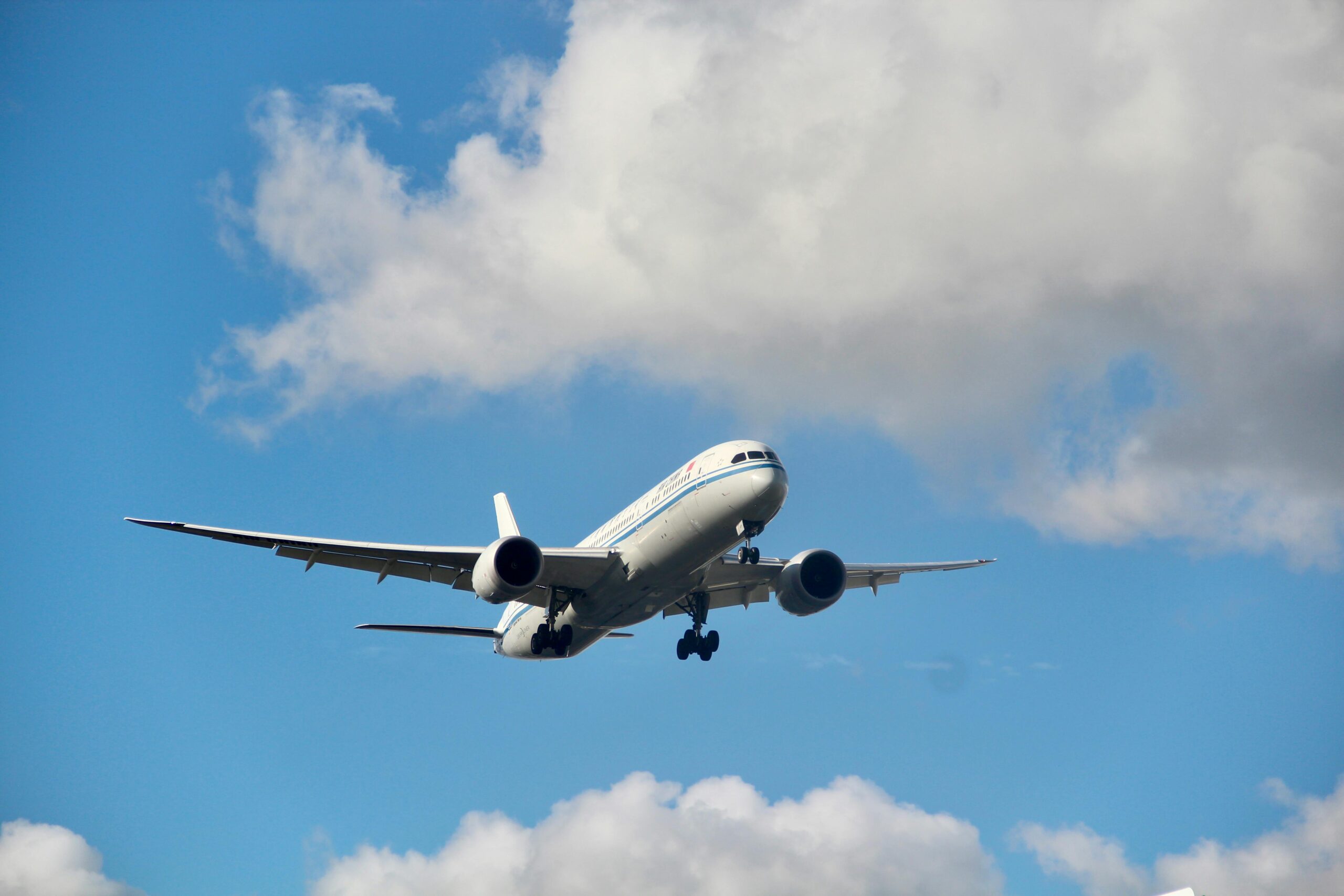 Flight booking service with airplane flying in clear blue sky