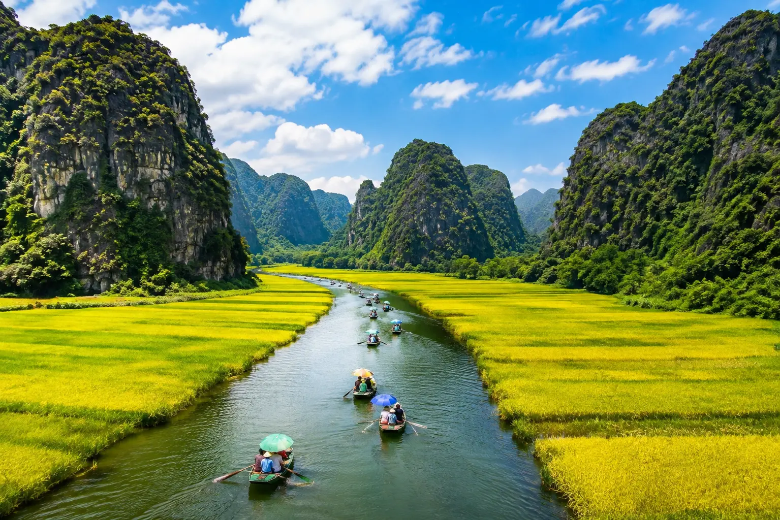 Scenic Tam Coc river with boats and limestone mountains in Ninh Binh, Vietnam