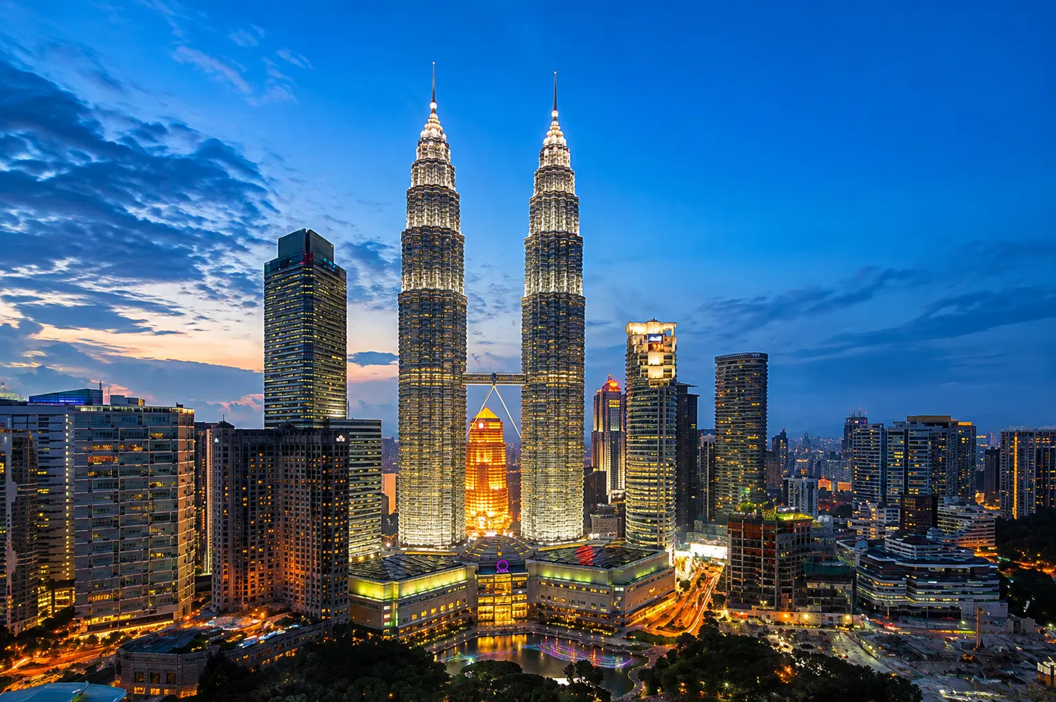Petronas Twin Towers in Kuala Lumpur with a vibrant evening city skyline